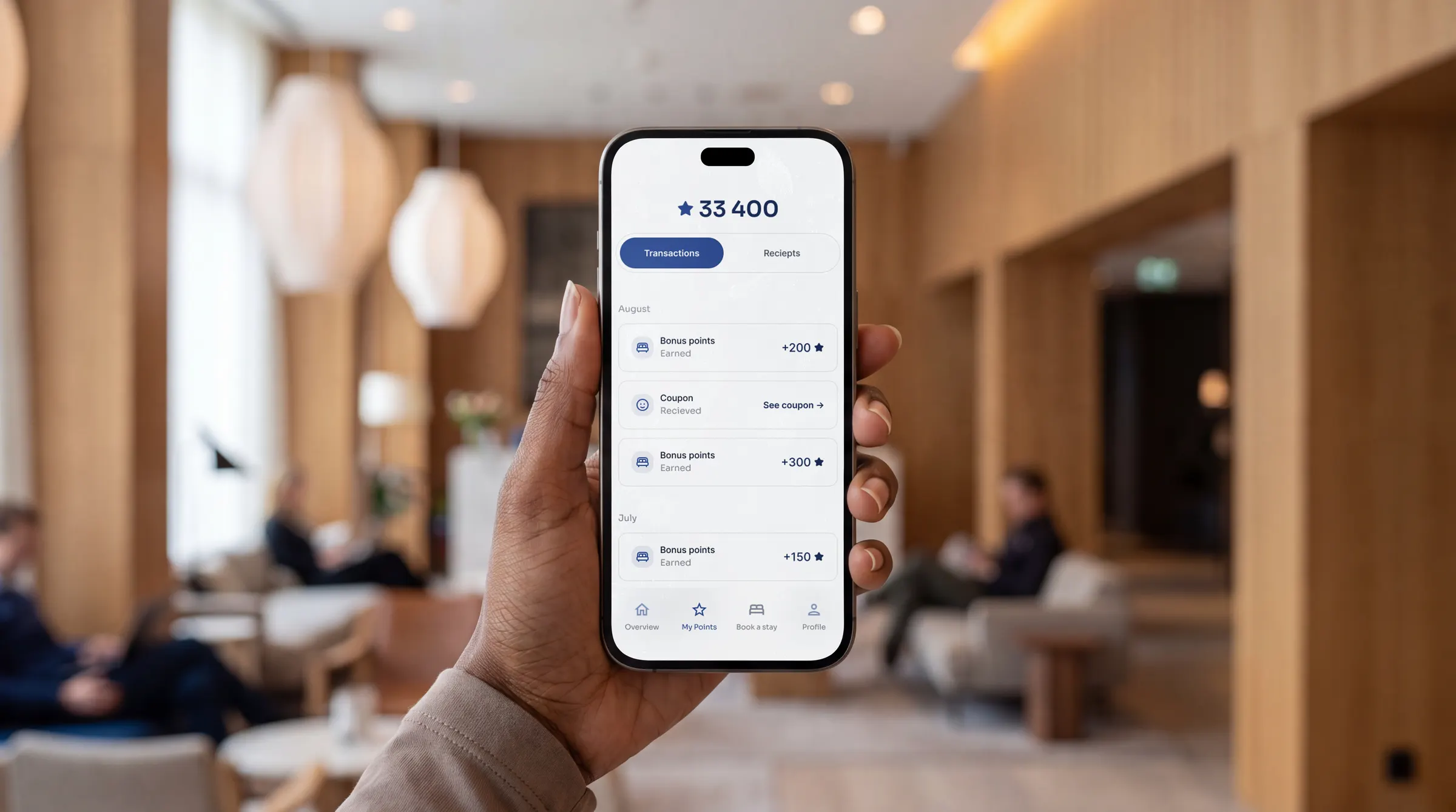 The Loyco Member Portal open on a phone in a hotel lobby, showing points balance and transactions